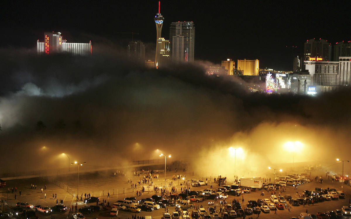 A cloud of dust from the Stardust hotel-casino rolls over spectators and media in the Frontier ...