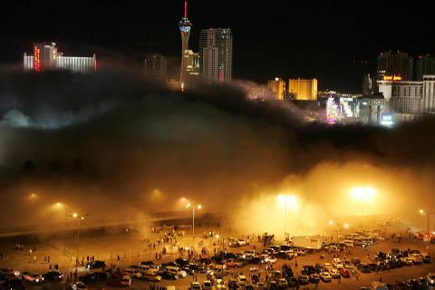 A cloud of dust from the Stardust hotel-casino rolls over spectators and media in the Frontier ...