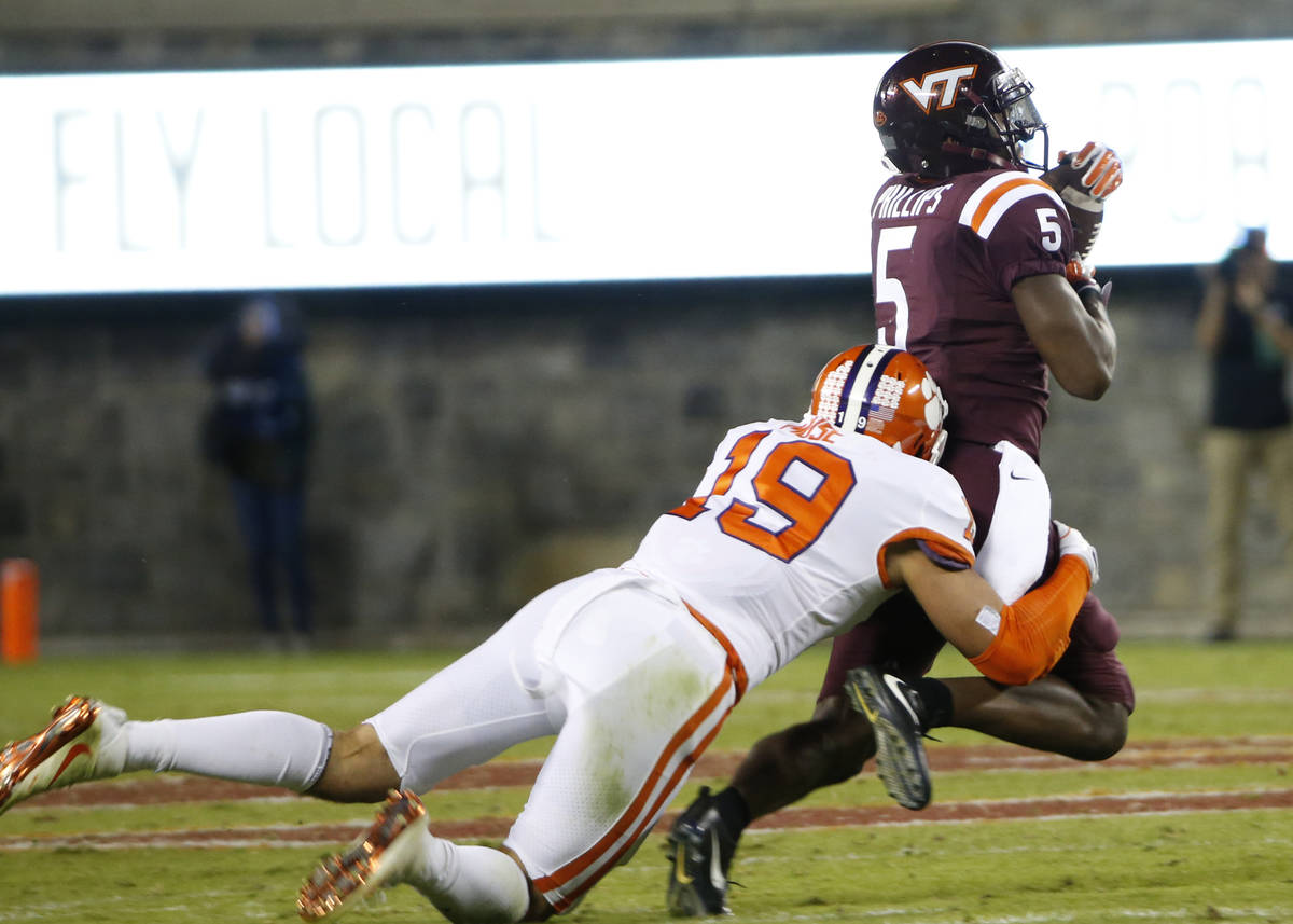 Virginia Tech wide receiver Cam Phillips (5) hauls in a pass as Clemson safety Tanner Muse (19) ...