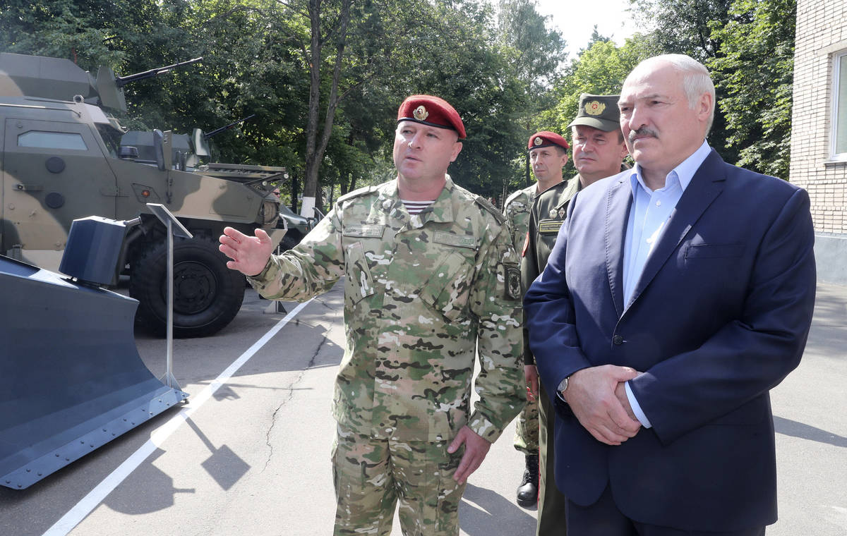 Belarus President Alexander Lukashenko, right, inspects police vehicles as he visits the Belaru ...