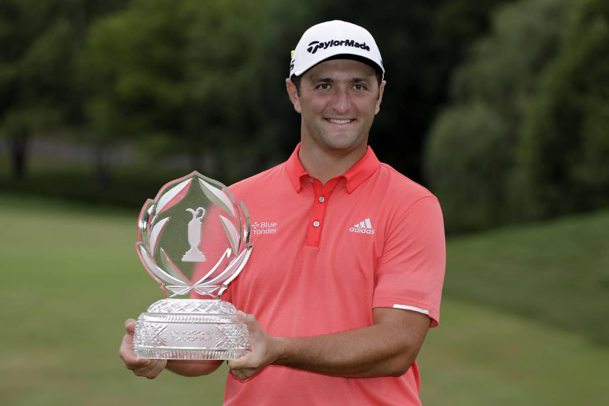 Jon Rahm, of Spain, poses with the trophy after winning the Memorial golf tournament in Dublin, ...