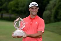 Jon Rahm, of Spain, poses with the trophy after winning the Memorial golf tournament in Dublin, ...
