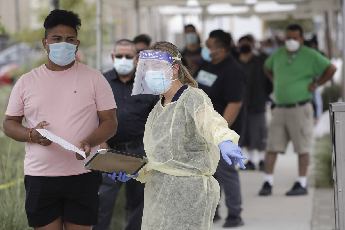In this July 22, 2020, file photo, people line up behind a health care worker at a mobile Coron ...