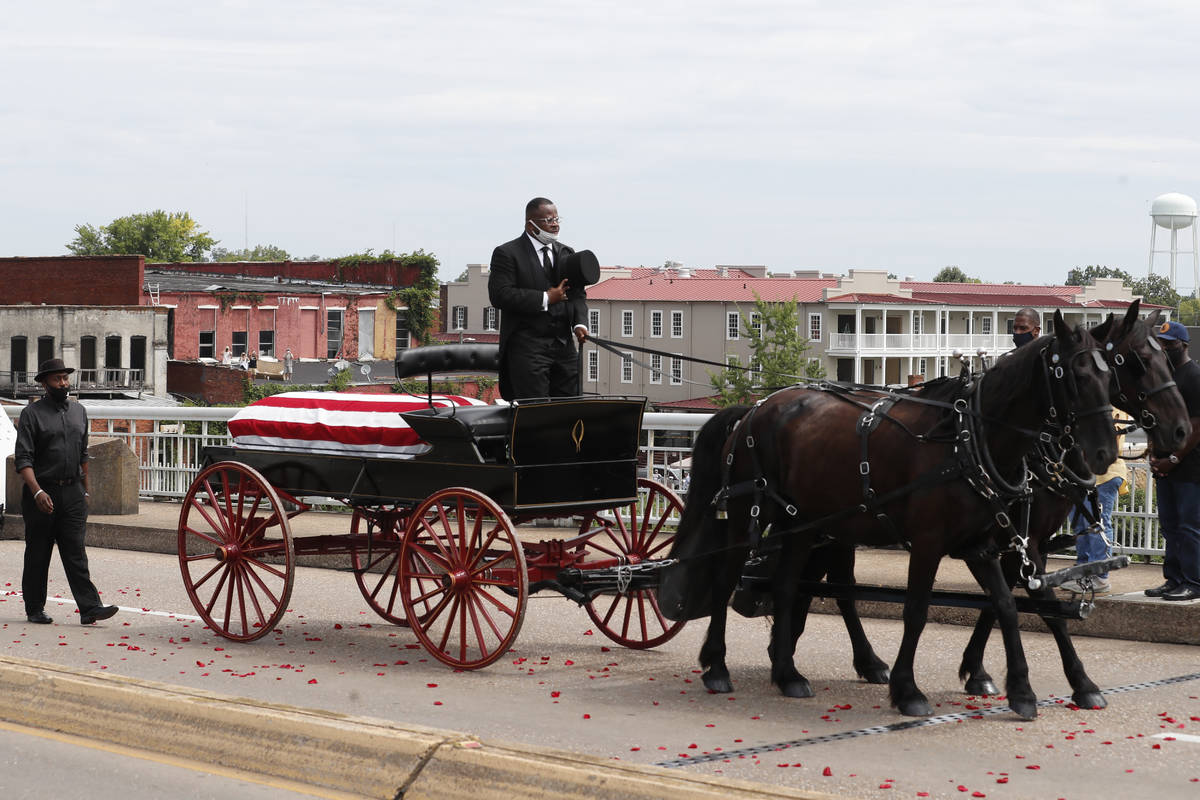 The casket of Rep. John Lewis moves over the Edmund Pettus Bridge by horse drawn carriage durin ...