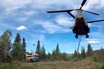 Alaska Army National Guard soldiers use a CH-47 Chinook helicopter to remove an abandoned bus, ...