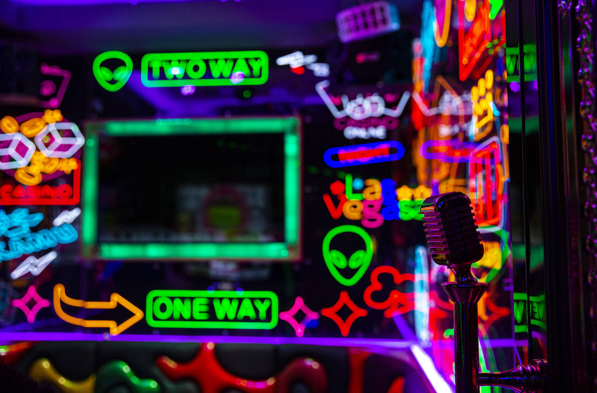 A door handle featuring a microphone in a room filled with neon at Kamu Karaoke at the Grand Ca ...