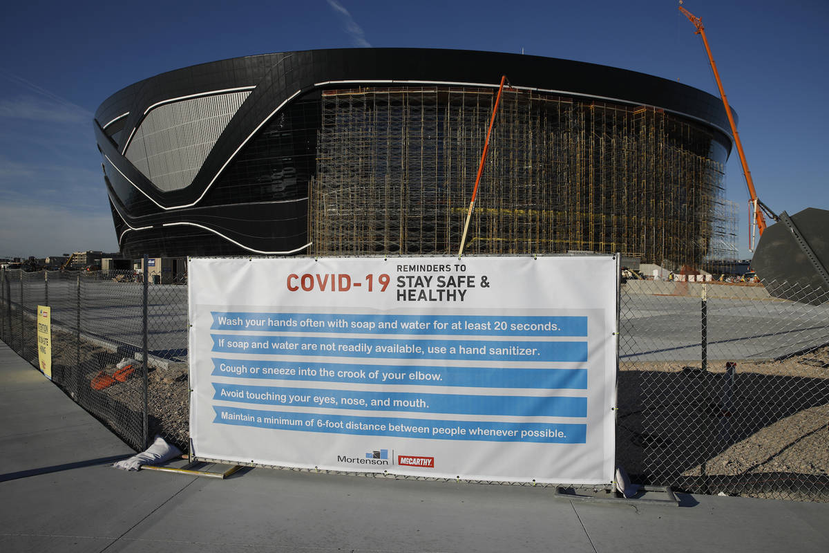 A sign gives guidelines for protection from COVID-19 as construction continues at Allegiant Sta ...