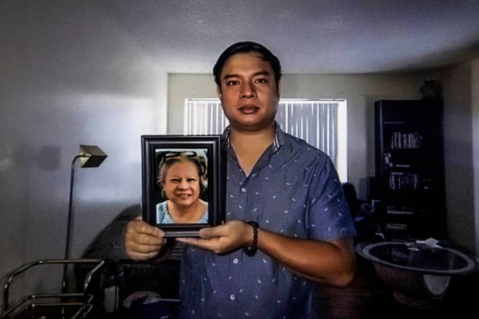 Roderick Alimusa holds a photograph of his mother, Maria Alimusa, at his home in Westminster, C ...