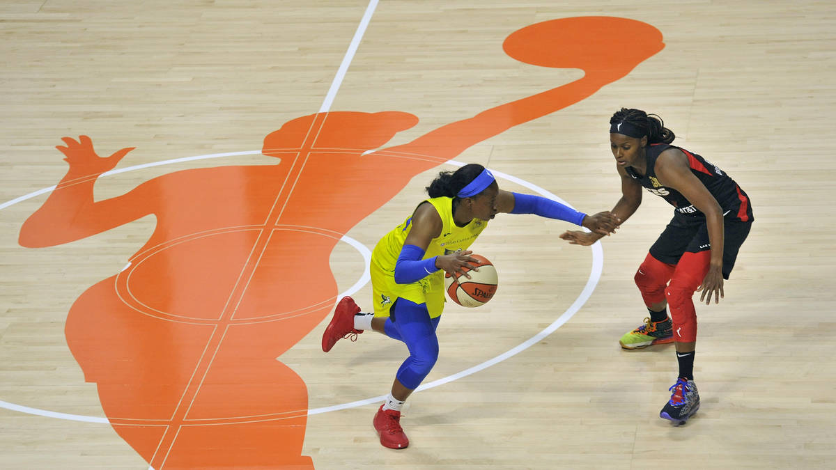 Dallas Wings' Arike Ogunbowale, left, moves the ball through midcourt as Las Vegas Aces' Sugar ...