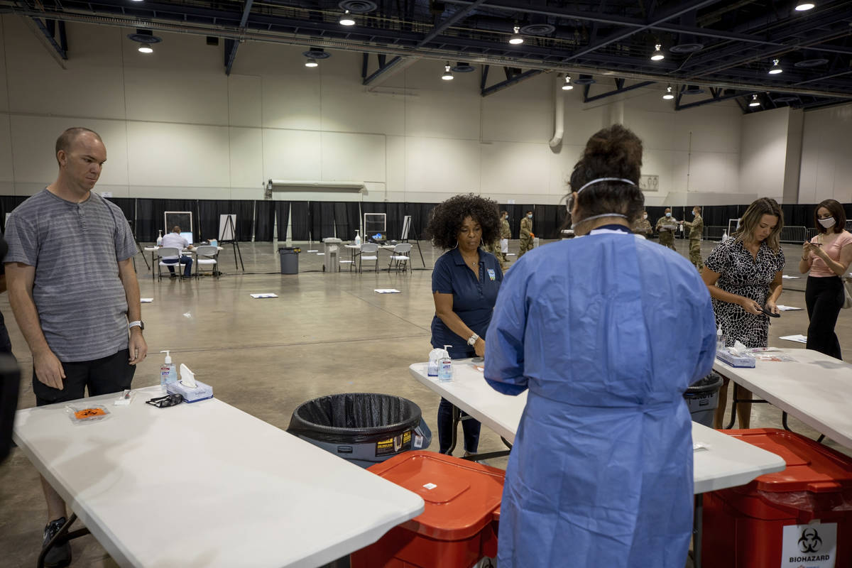 Individuals complete a COVID-19 test during a preview of a new COVID-19 testing site inside Cas ...