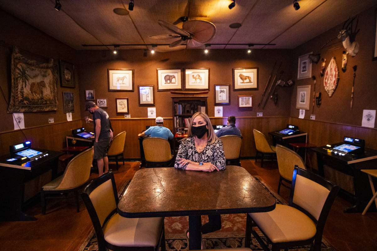 Donna Rocker, owner of Black Mountain Grill, poses by a gaming lounge area at the restaurant an ...