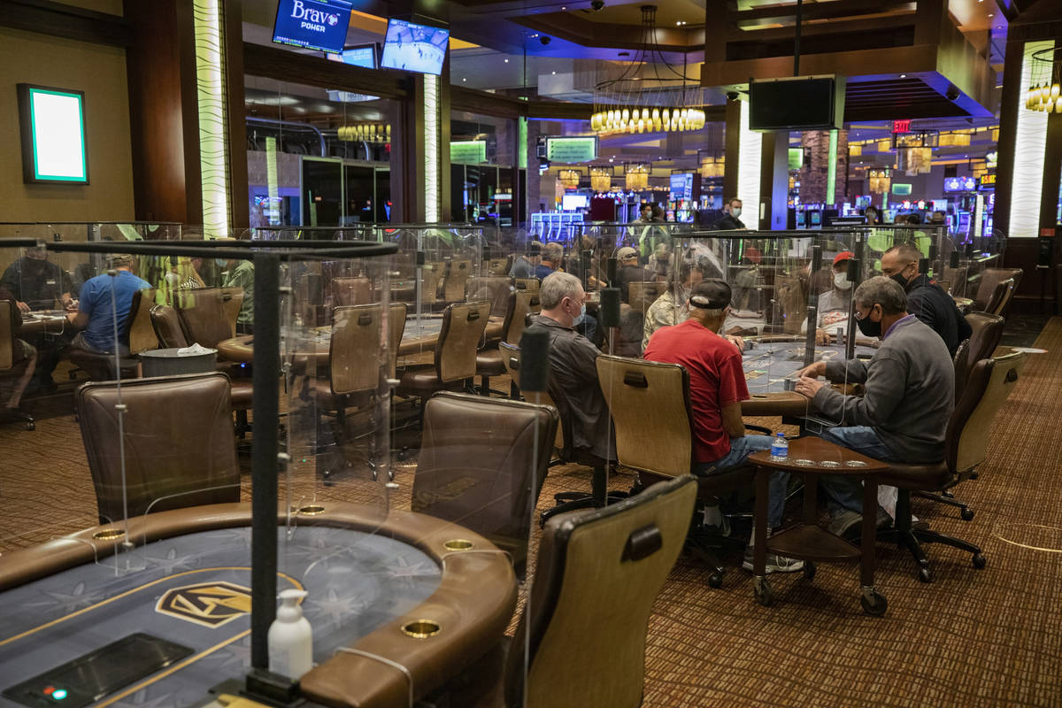 Individuals play eight-handed poker games using plexiglass dividers between the players in the ...