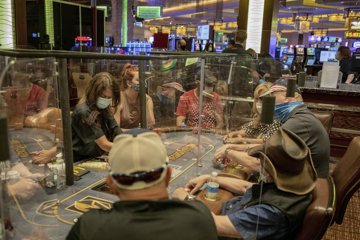 Individuals play eight-handed poker games using plexiglass dividers between the players in the ...