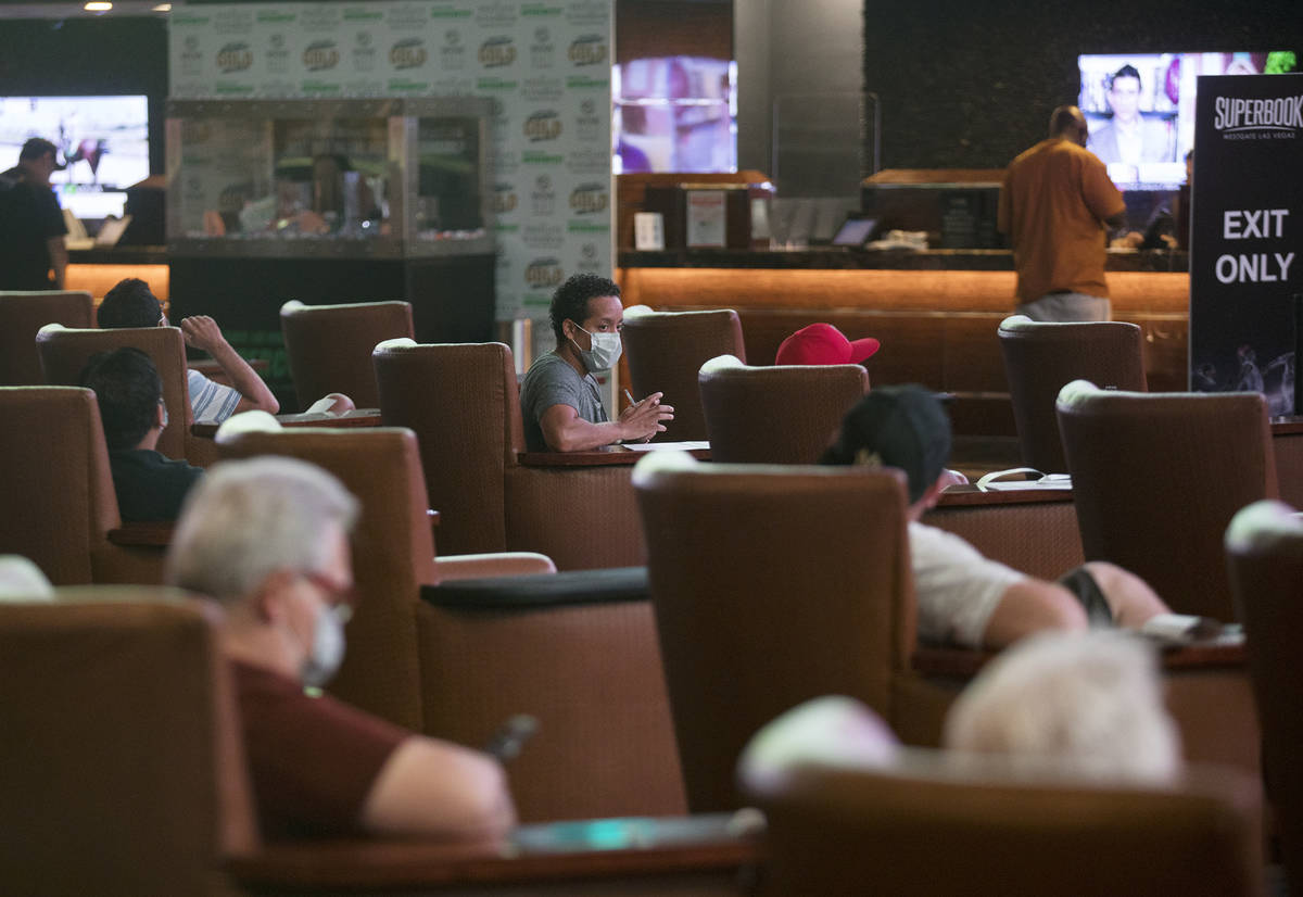 Guests watch the screens at the Westgate sportsbook in Las Vegas, Thursday, Aug. 6, 2020. (Rach ...