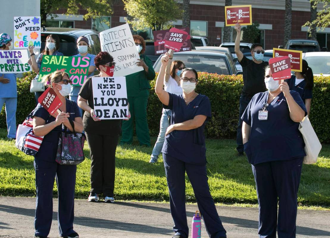 Registered Nurses Zully Hernandez, center and Aariana Kovacs, right, picket outside of St. Rose ...