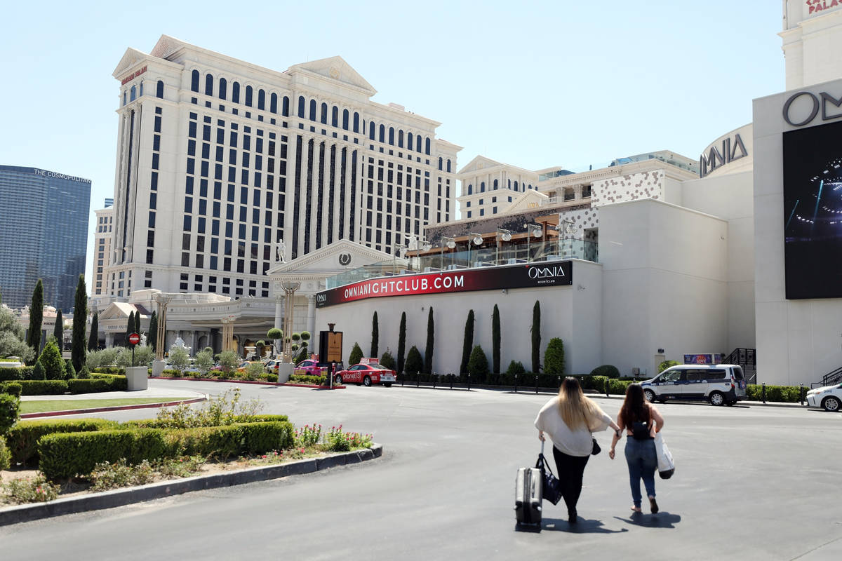 Guests walk to Caesars Palace hotel and casino on the Las Vegas Strip, Thursday, Aug. 6, 2020, ...