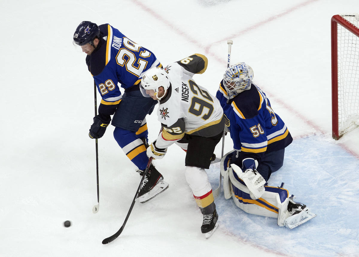 St. Louis Blues' Vince Dunn (29) and Vegas Golden Knights' Tomas Nosek (92) battle in front as ...