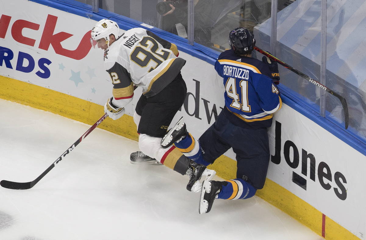 St. Louis Blues' Robert Bortuzzo (41) is checked by Vegas Golden Knights Tomas Nosek (92) durin ...