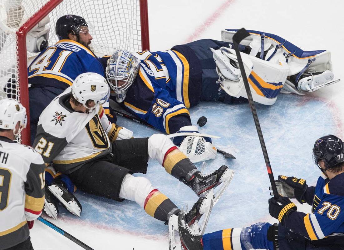 St. Louis Blues goalie Jordan Binnington (50) makes a save as players crash into the net during ...