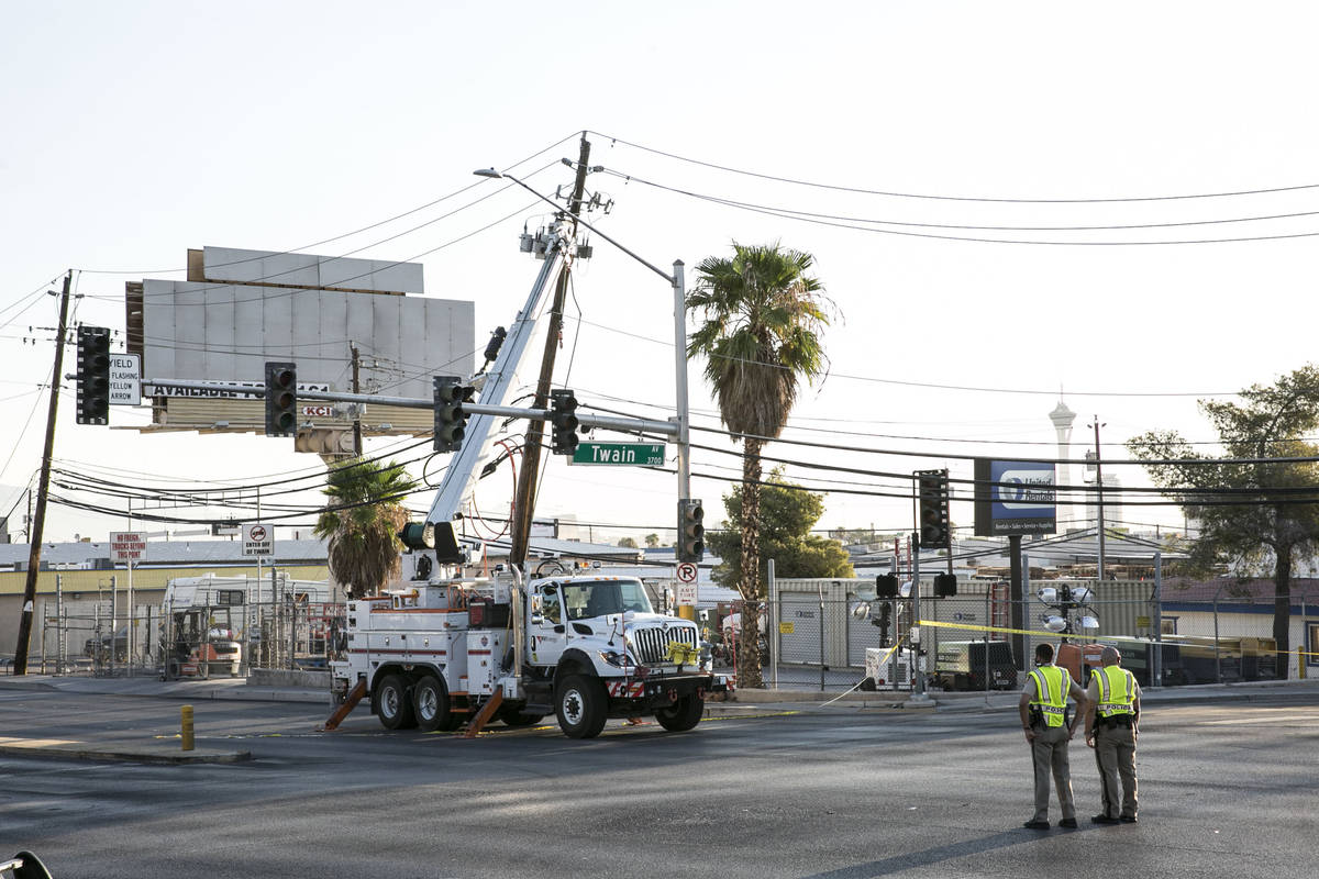 Electrical workers repair power line after a woman motorist struck a power pole and power box n ...
