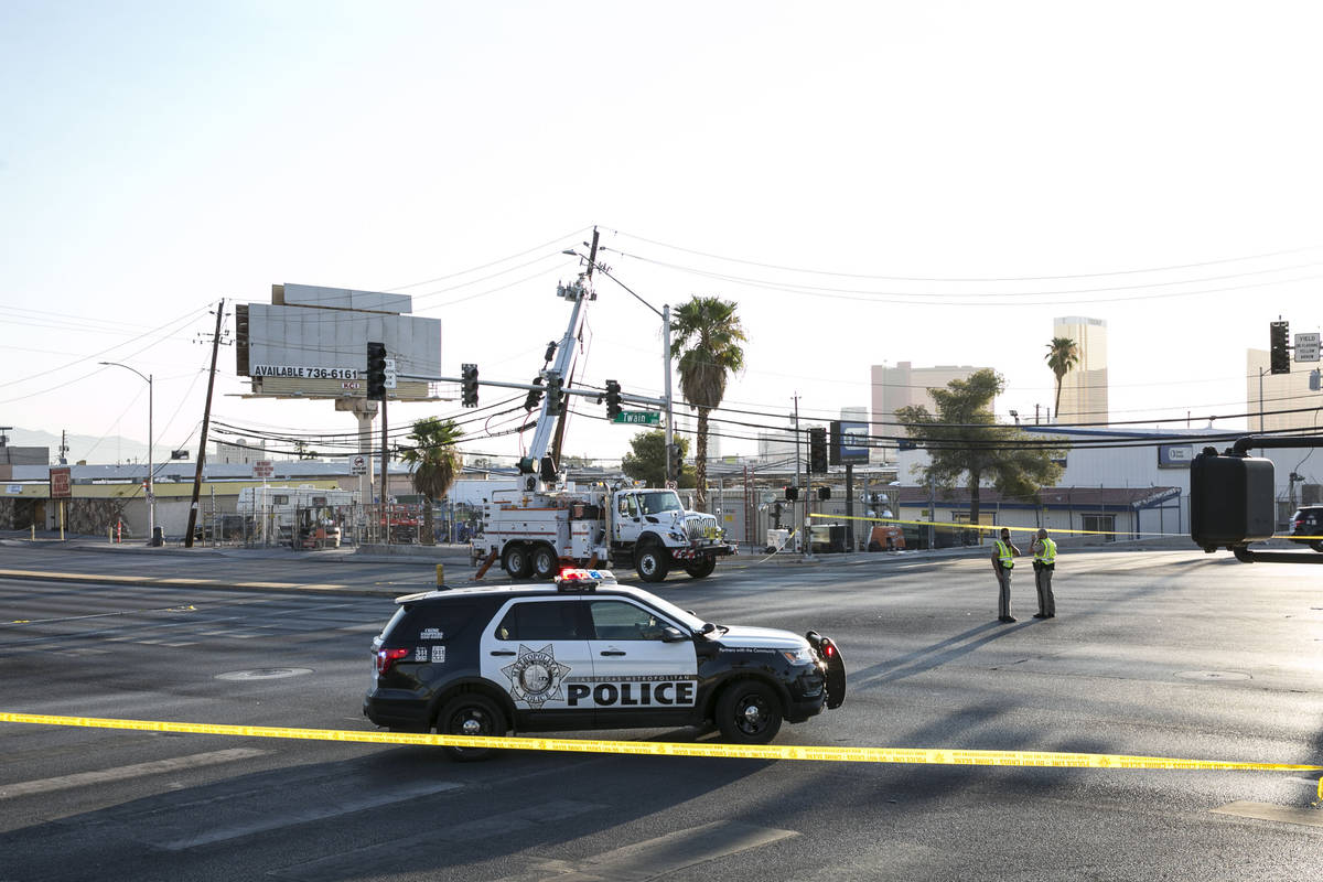 Electrical workers repair power line after a woman motorist struck a power pole and power box n ...