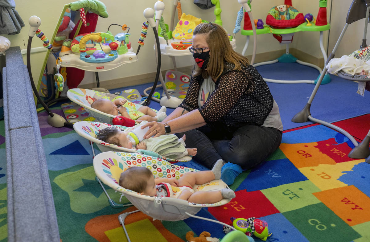 Ms. Marilyn Leyson feeds an infant in the newborn room during the first day of school at Shenke ...