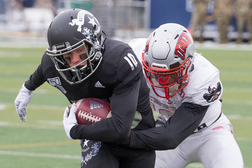 Nevada wide receiver Ben Putman (10) is grabbed by UNLV linebacker Javin White (16) in the firs ...