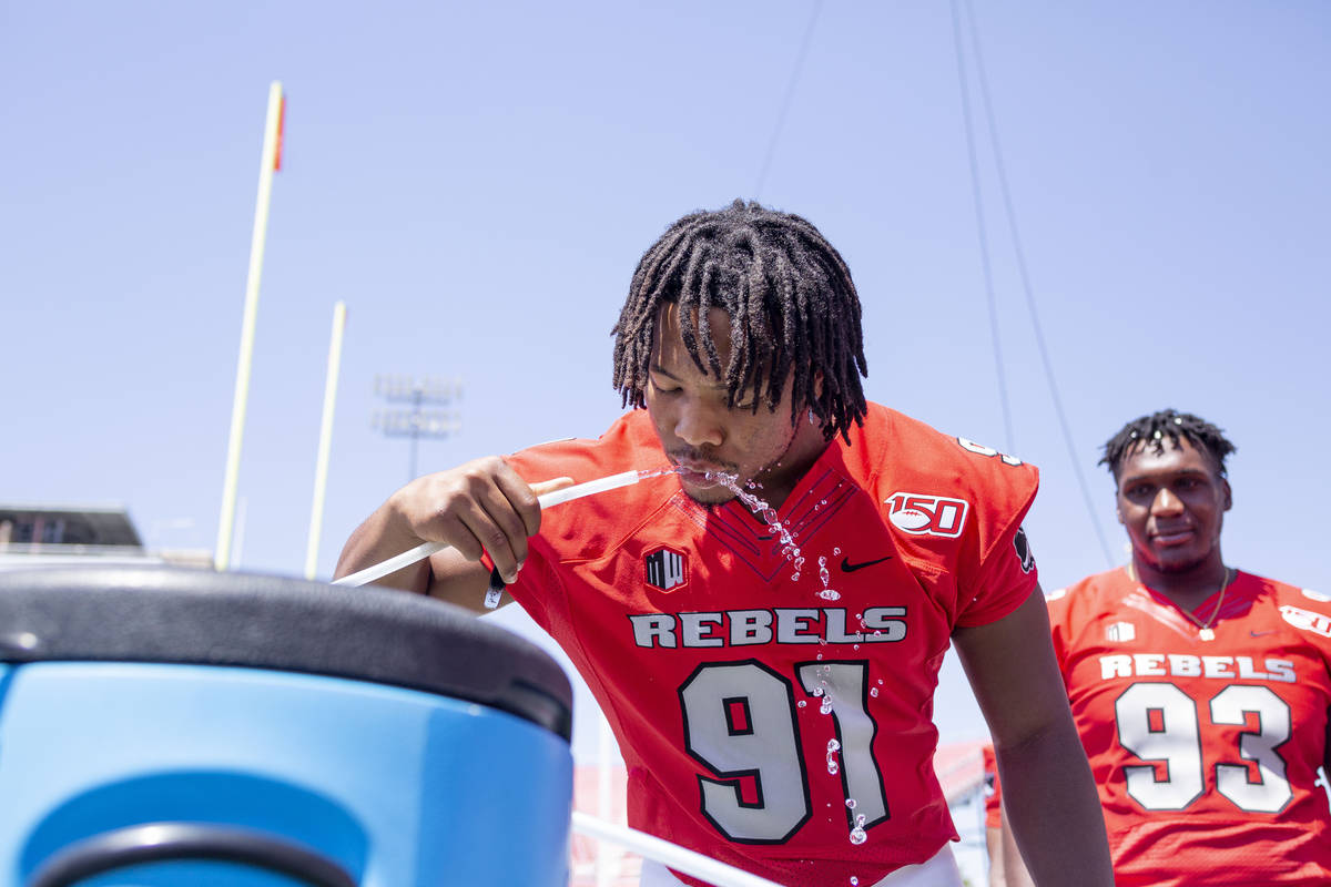 UNLV's defensive line Nate Neal (91) hydrates during the team's photo day at Sam Boyd Stadium i ...