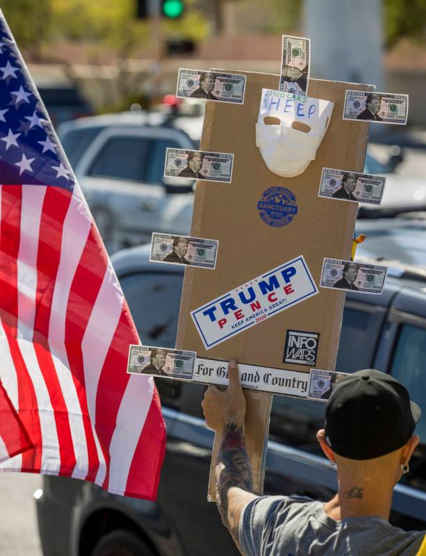 A variety of signs are displayed during the No Mask Nevada rally to oppose the face mask mandat ...