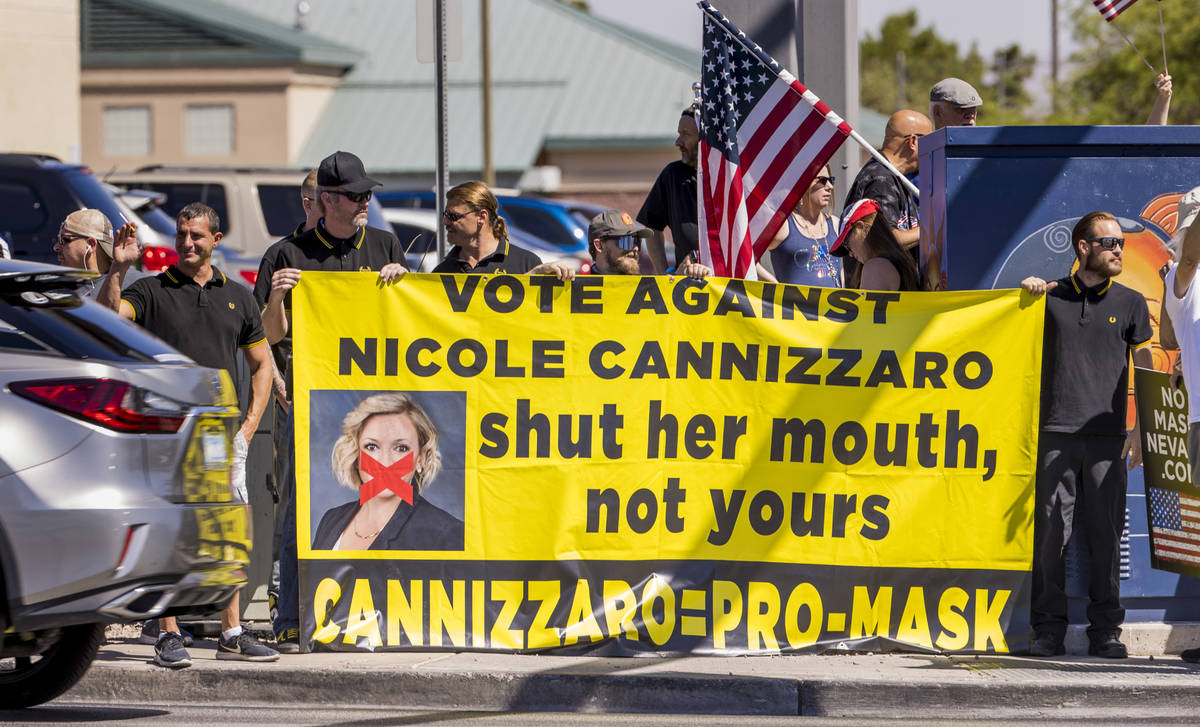 Nevada Proud Boys display a banner against state Sen. Nicole Cannizzaro during a No Mask Nevada ...