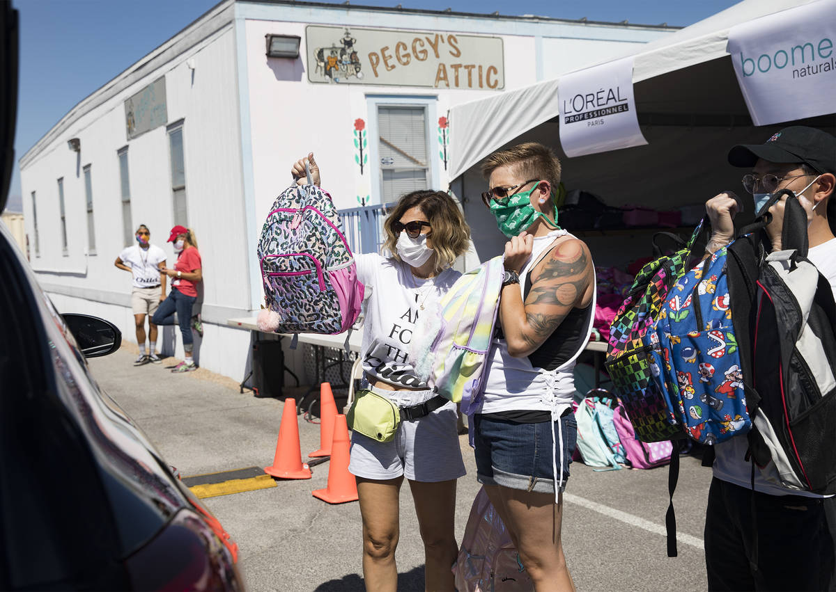 Volunteers Theresa Broussard, left, and Alexis Von Schlieder, center, and Dillon Mones, right, ...