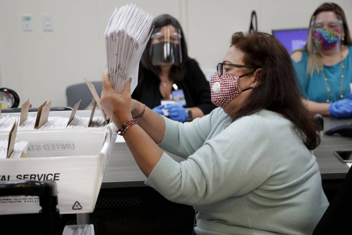 Miami-Dade County Department of Elections employee Elizabeth Prieto gathers vote-by-mail ballot ...