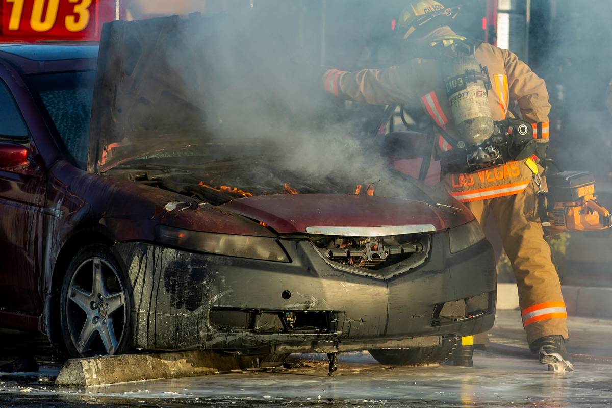 The engine is still on fire as Las Vegas Firefighters cut open the hood in the Mariana's Superm ...
