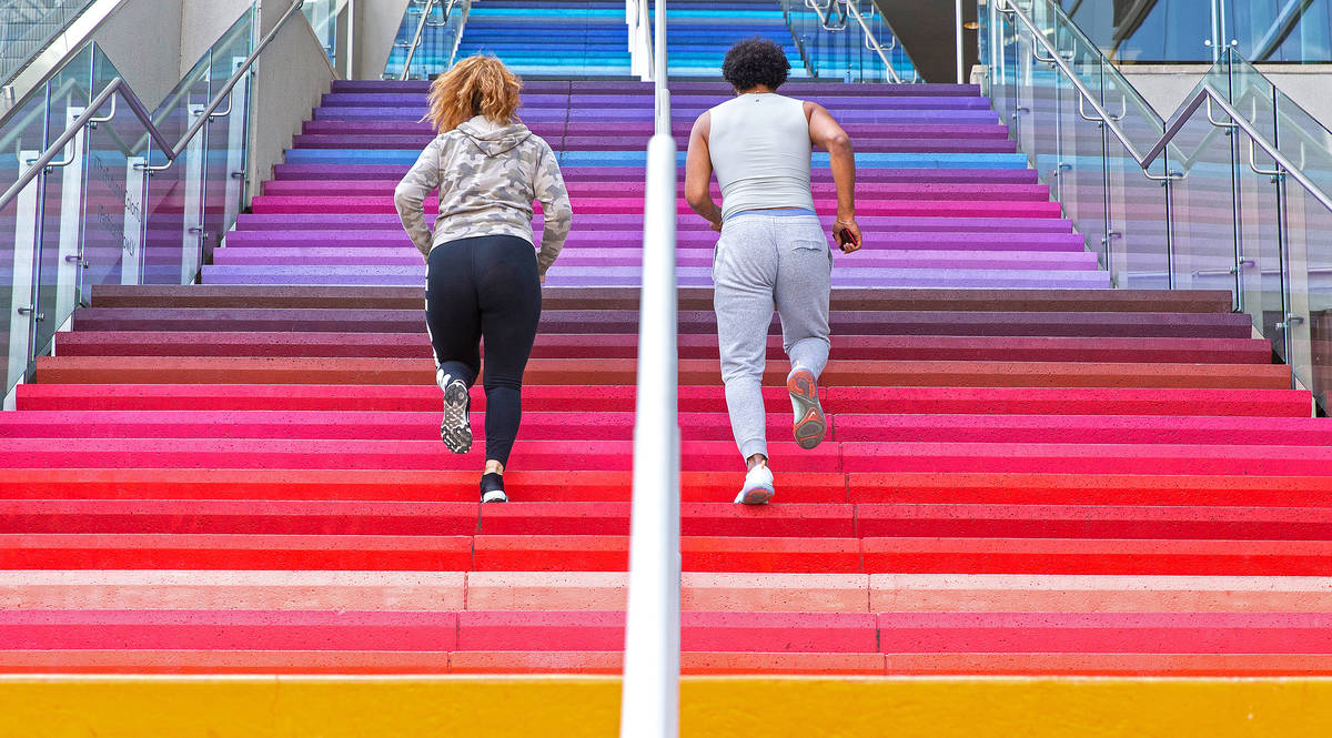 Jared Jenkins, right, and Kayla Muaina run the stairs outside Fashion Show mall on the Strip on ...