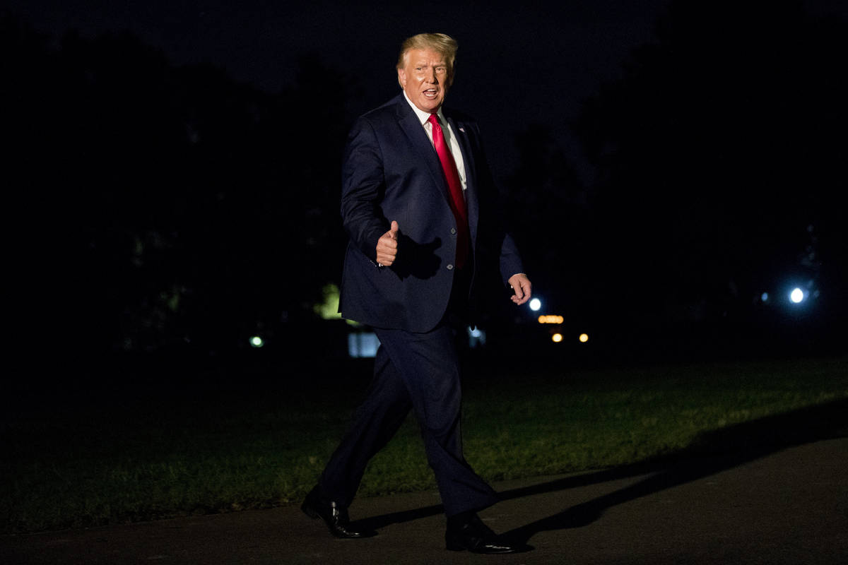 President Donald Trump gives a thumbs-up to members of the media as he walks across the South L ...