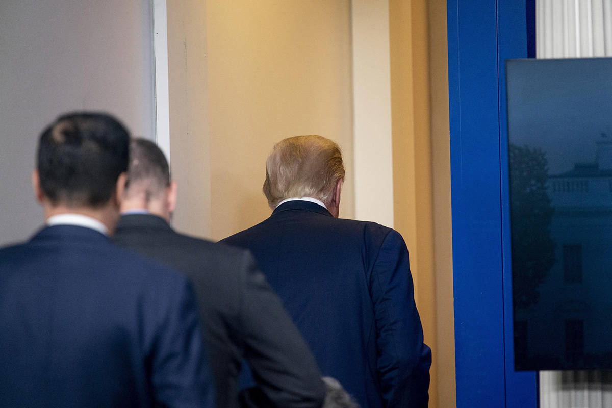 President Donald Trump leaves the James Brady Press Briefing Room by a member of the Secret Ser ...