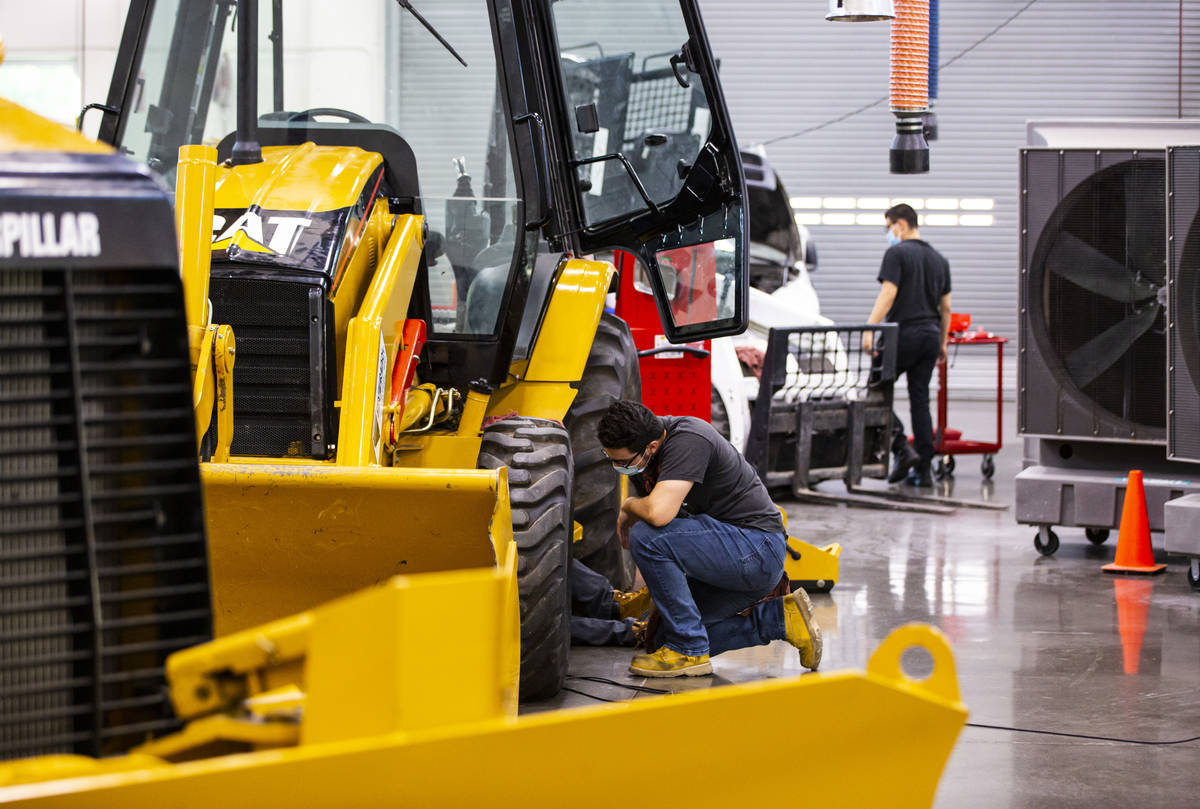 Student Samuel Branch, of Henderson, checks on his partner while working on a backhoe loader du ...