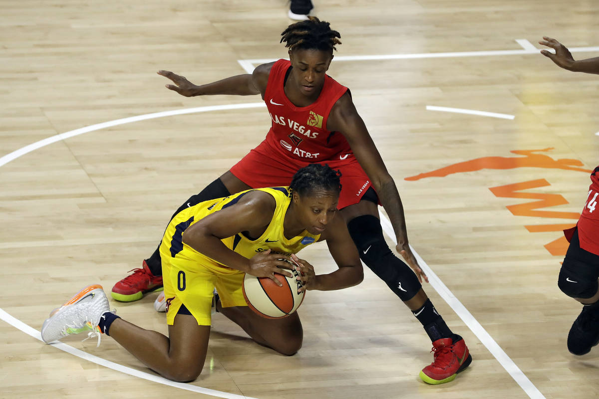 Indiana Fever guard Kelsey Mitchell (0) falls down in front of Las Vegas Aces forward Dearica H ...