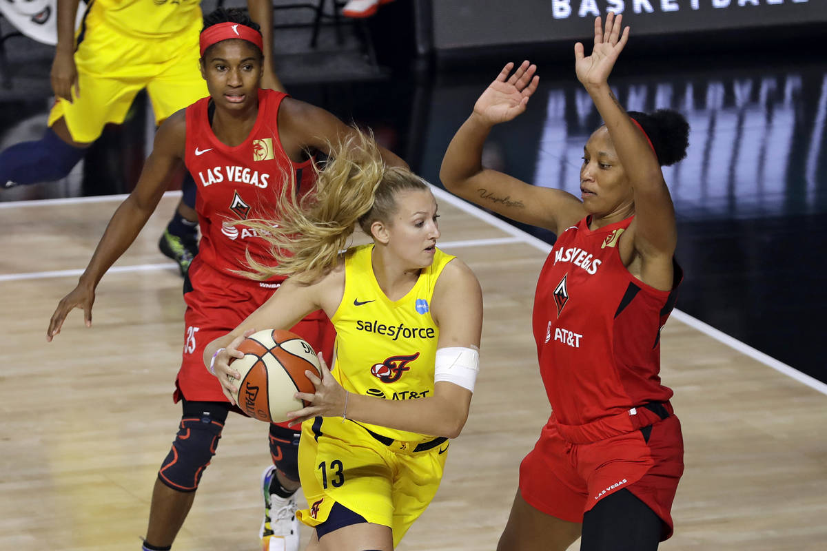 Indiana Fever forward Lauren Cox (13) drives into Las Vegas Aces center A'ja Wilson (22) and fo ...