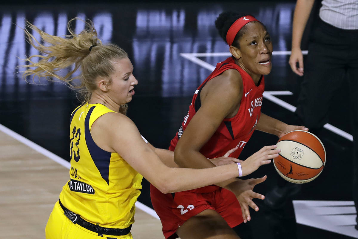 Las Vegas Aces center A'ja Wilson (22) drives around Indiana Fever forward Lauren Cox (13) duri ...