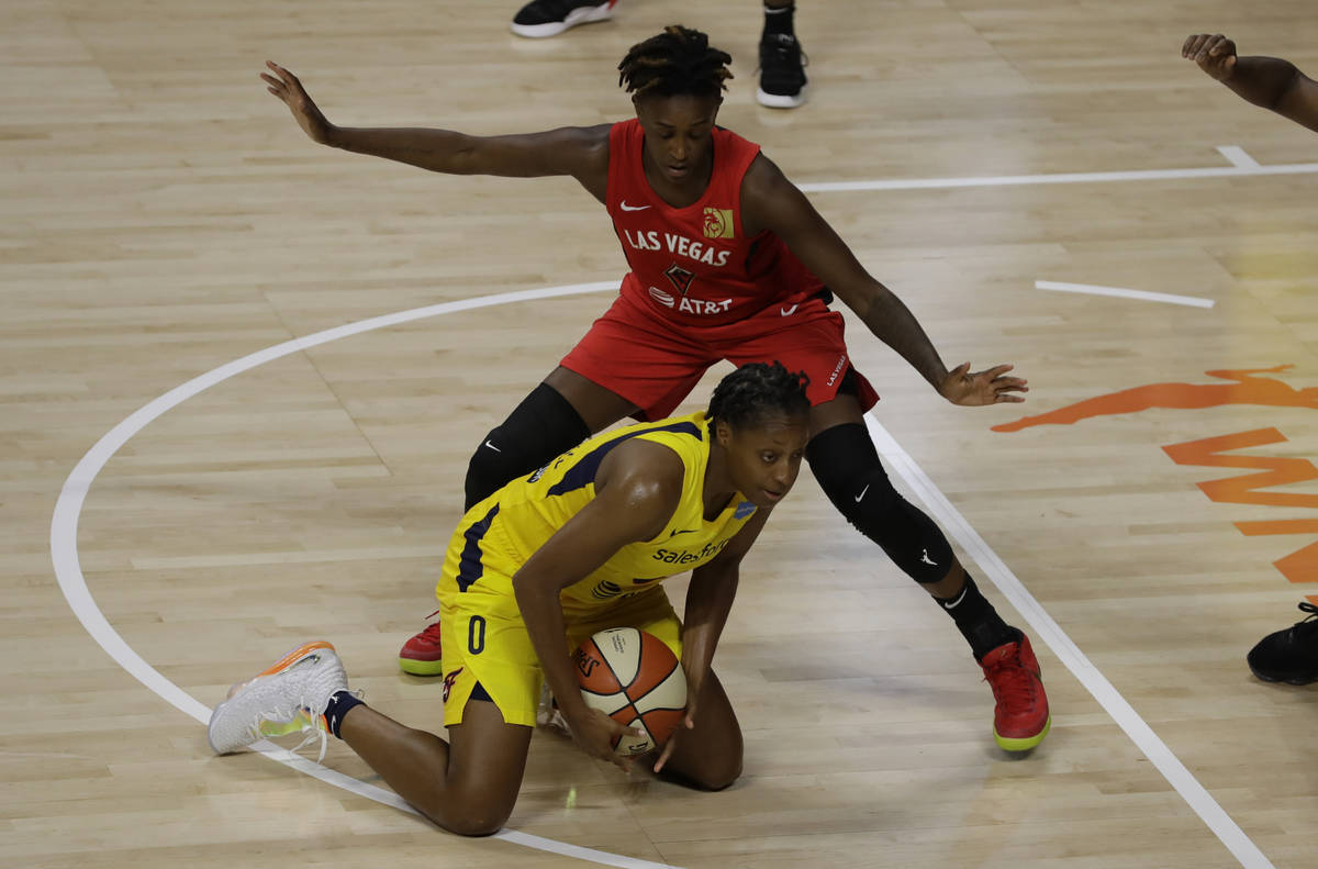 Indiana Fever guard Kelsey Mitchell (0) falls down in front of Las Vegas Aces guard Danielle Ro ...