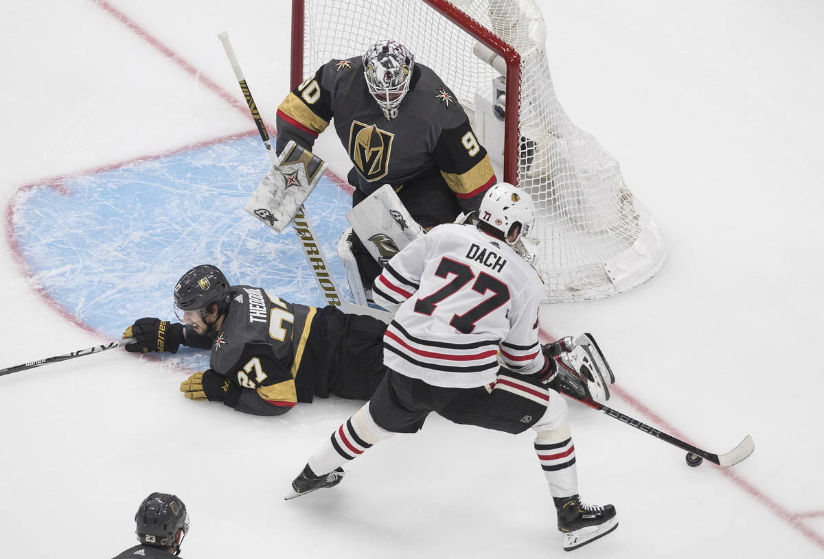 Chicago Blackhawks' Kirby Dach (77) is blocked by Vegas Golden Knights' Shea Theodore (27) as G ...