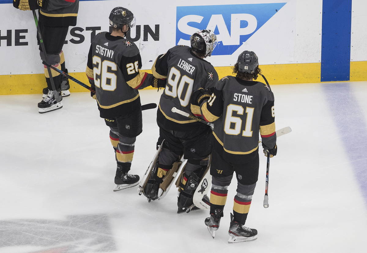 Vegas Golden Knights goalie Robin Lehner (90) is helped to the bench by Mark Stone (61) and Pau ...