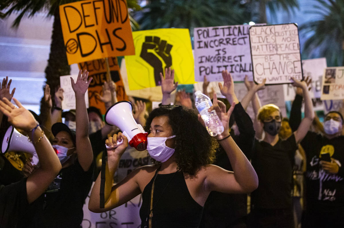 Rally organizer Nakitaa Fletcher holds up her hands as people march for Black Lives Matter and ...