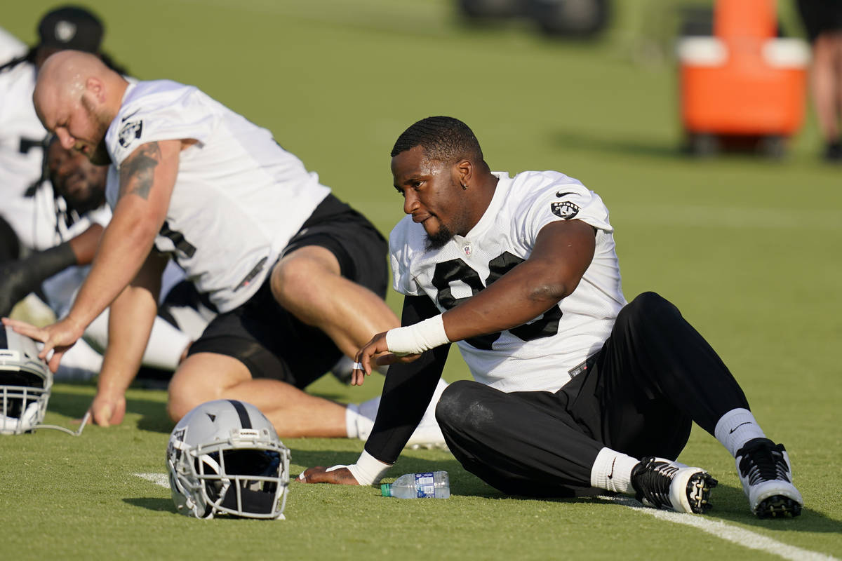 Las Vegas Raiders defensive end Clelin Ferrell, right, stretches during an NFL football trainin ...