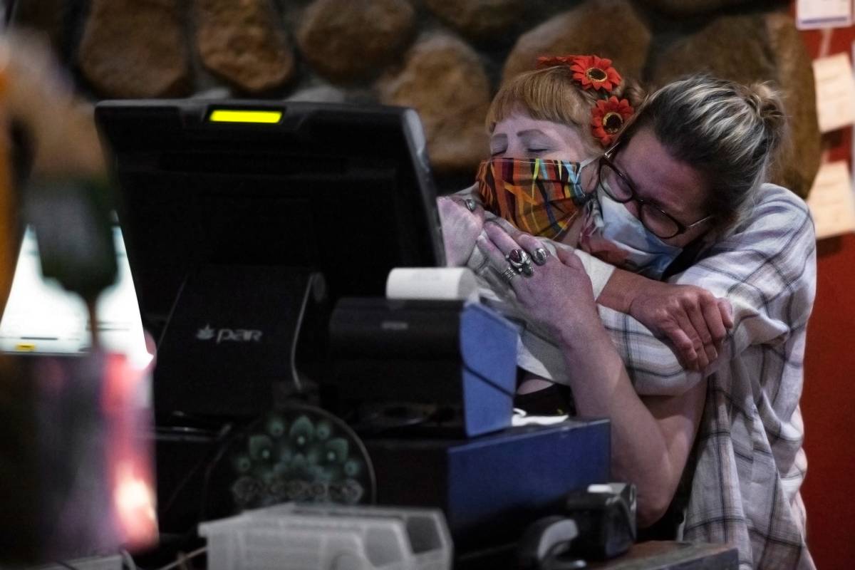 Bartenders Teah Heath, left, and Dawn Smith share a hug minutes before last call at Jackson&#x2 ...