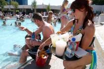 A cocktail server brings drinks and food to customers at the Wet Republic adult pool and beach ...