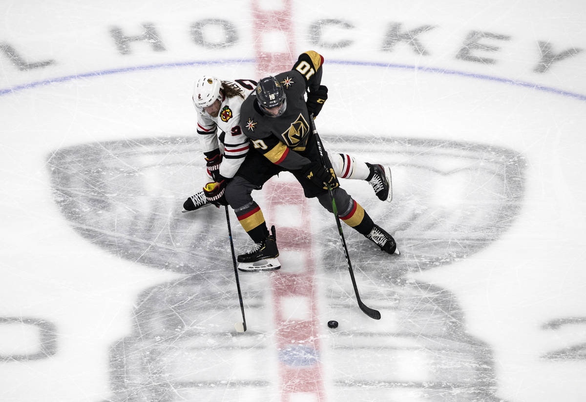 Vegas Golden Knights' Nicolas Roy (10) and Chicago Blackhawks' Duncan Keith (2) battle for the ...