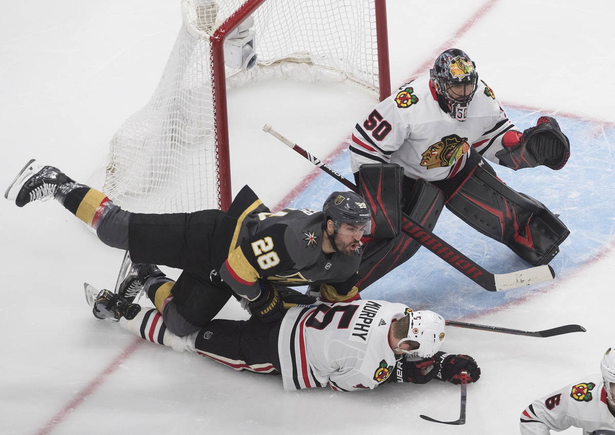 Vegas Golden Knights' William Carrier (28) and Chicago Blackhawks' Connor Murphy (5) battle as ...