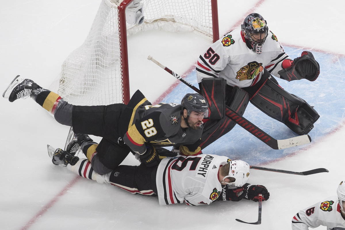 Vegas Golden Knights' William Carrier (28) and Chicago Blackhawks' Connor Murphy (5) battle as ...